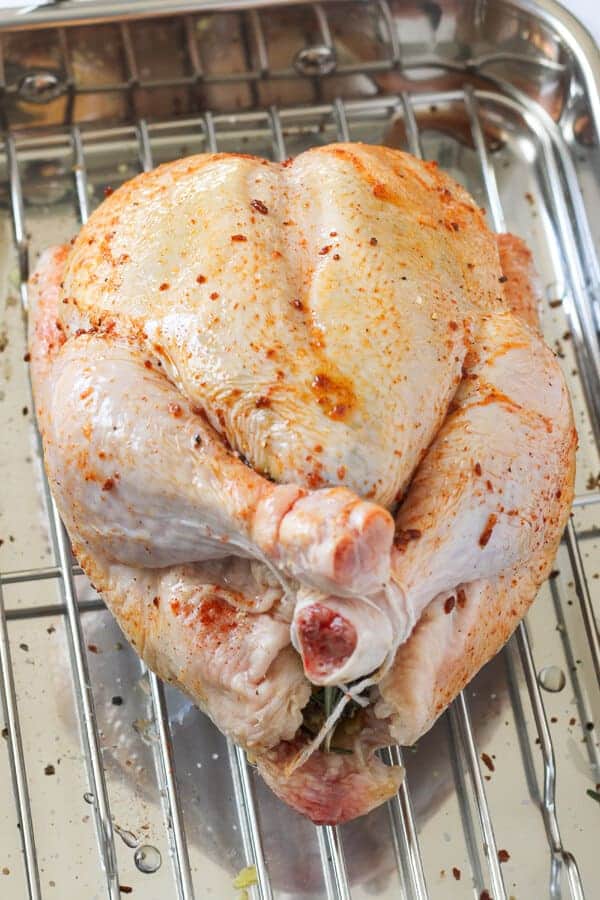 Whole chicken on a baking tray ready for the oven.