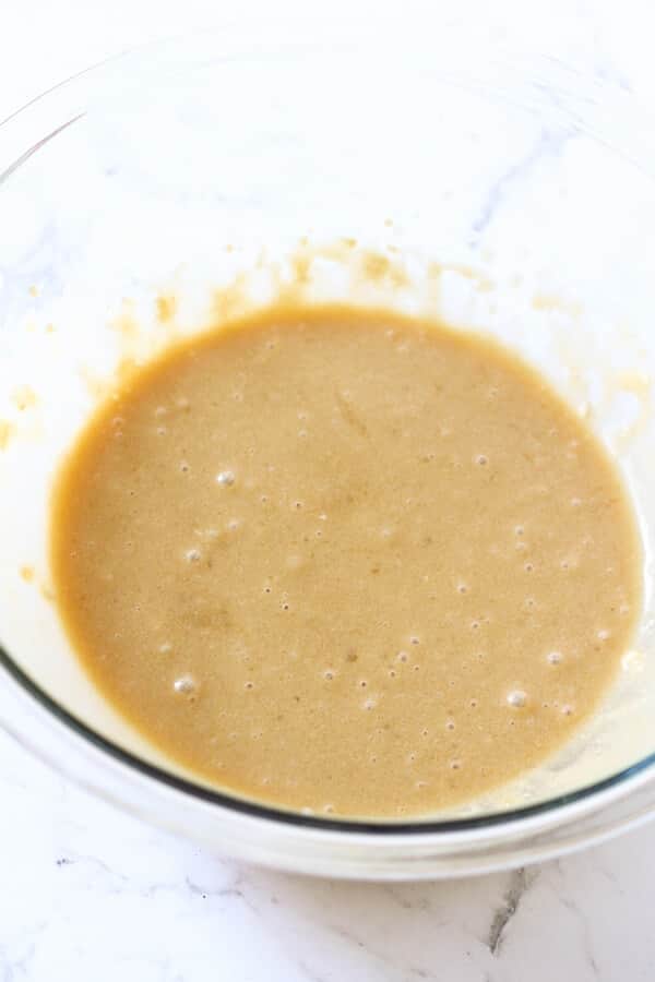banana bread ingredients mixed in a glass bowl. 