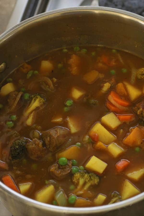 ingredients for curried sausages in a large pot. 