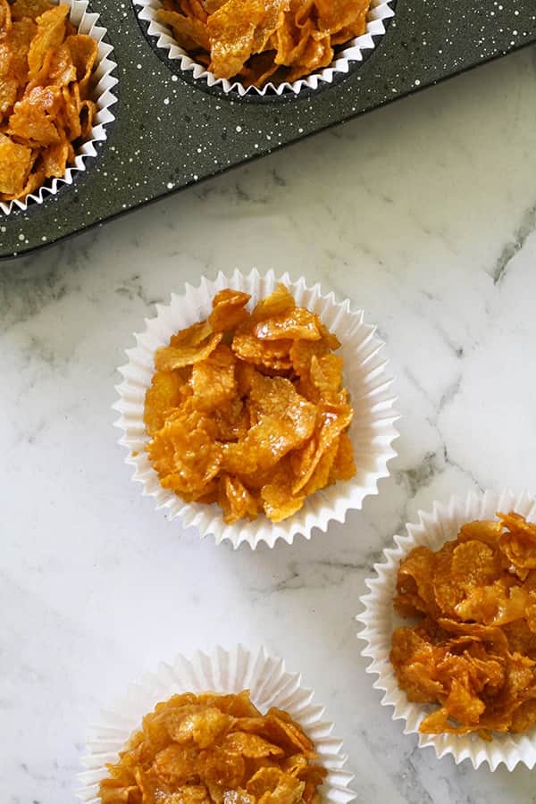 Honey joys in white paper liners on a marble background.