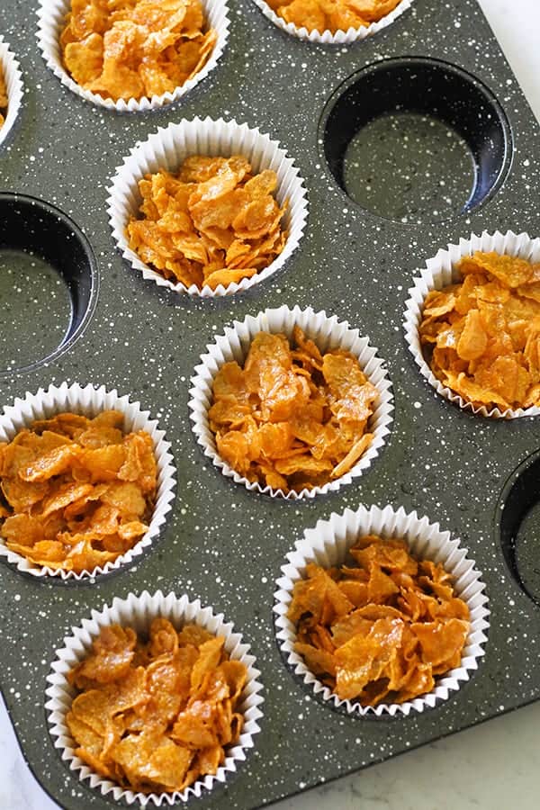 Honey joys in white paper liners in a muffin tin.