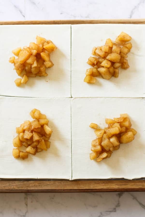puff pastry cut into squares with spoonfuls of diced apple in the centre.