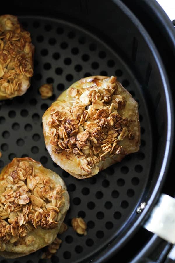 cooked baked apples in an air fryer basket.
