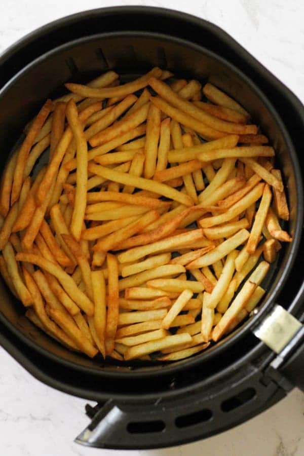 french fries in an air fryer basket.