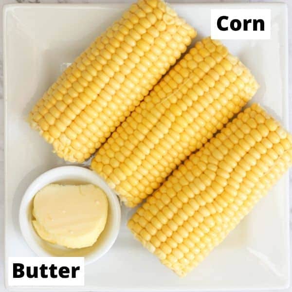 3 ears of corn and some butter on a white plate.