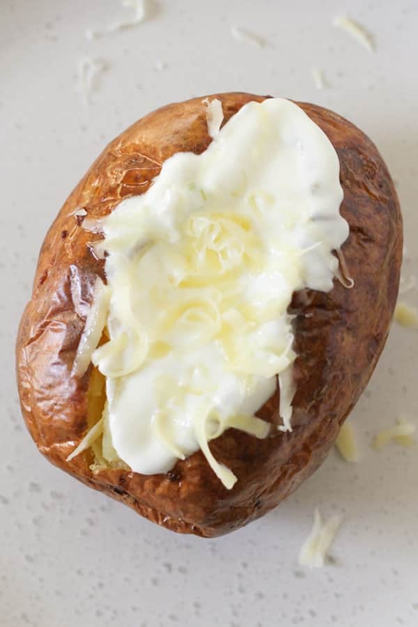 baked potato topped with sour cream and cheese.