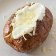 baked potato topped with sour cream and cheese.
