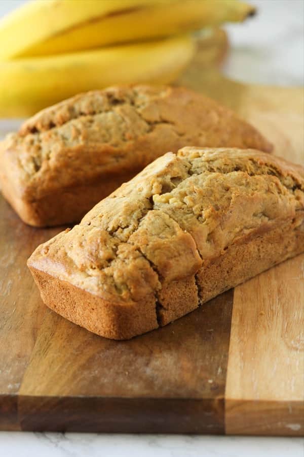 Mini banana loaves on a wooden cutting board.