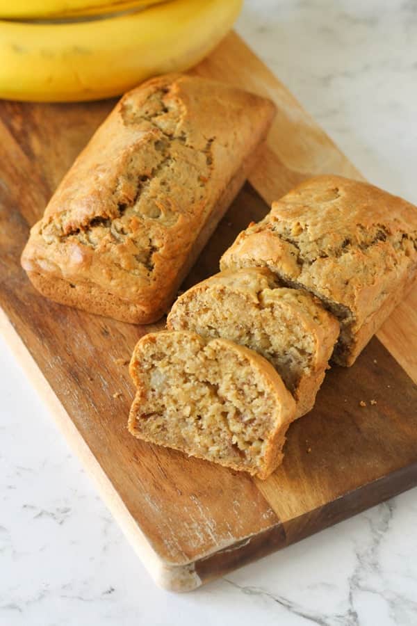 Mini banana loaves on a wooden cutting board.