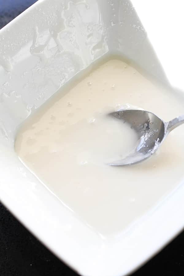 cinnamon roll glaze in a white bowl.