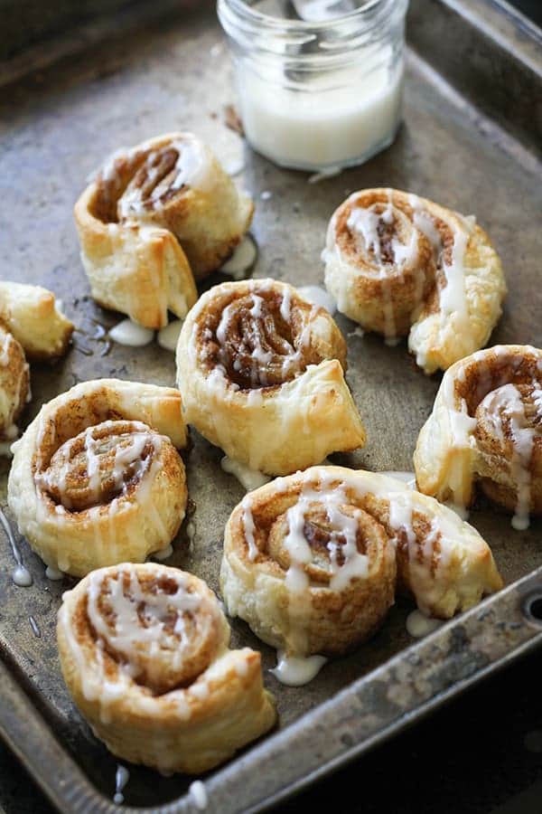 cinnamon rolls in a baking tray covered in glaze.