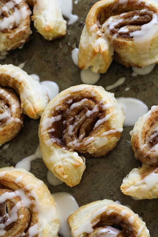 cinnamon rolls on a baking tray covered in glaze.