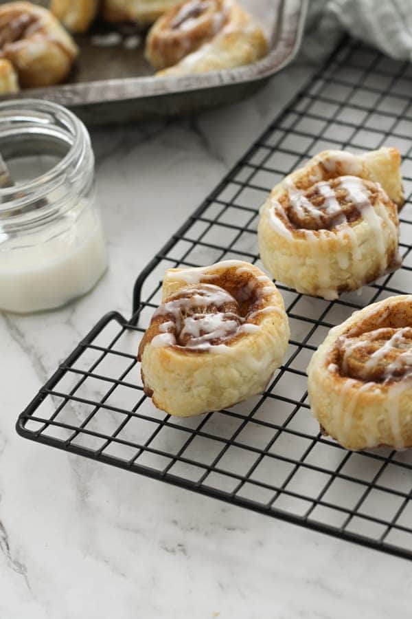cinnamon rolls on a wire rack.