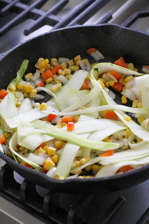 vegetables frying in a cast iron pan.