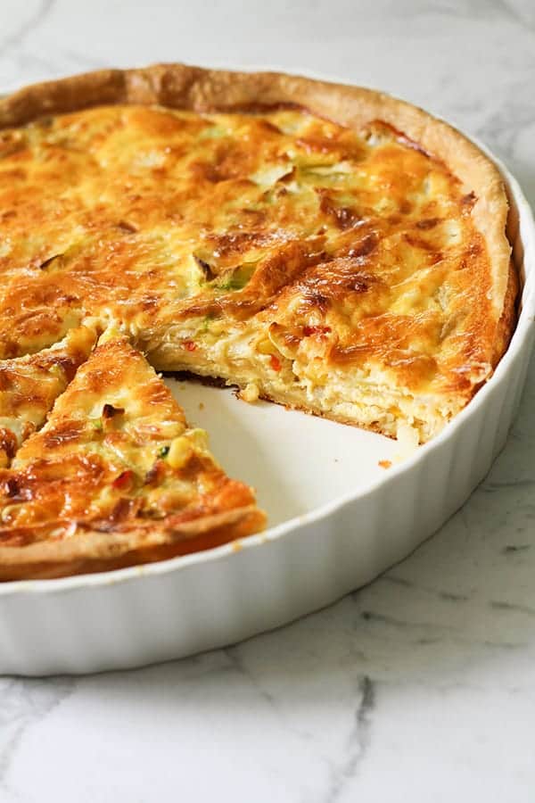 vegetarian quiche in a white quiche dish.