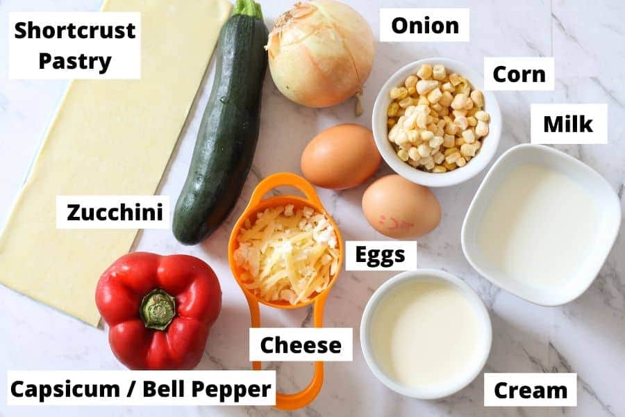 ingredients for vegetarian quiche on a white marble background./