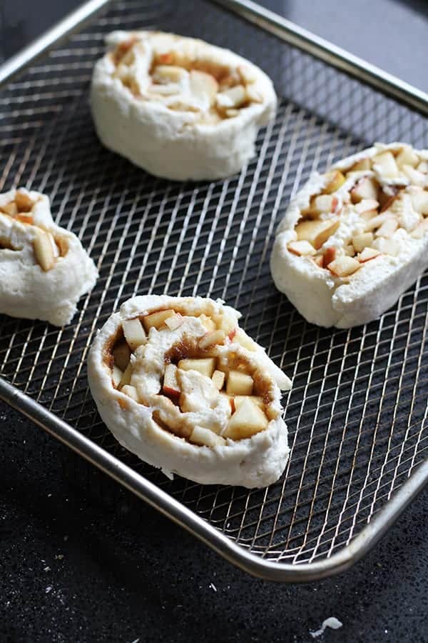 apple cinnamon rolls in air fryer basket.