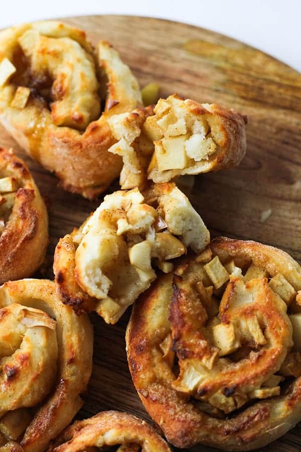 air fryer apple cinnamon rolls on a wooden cutting board.