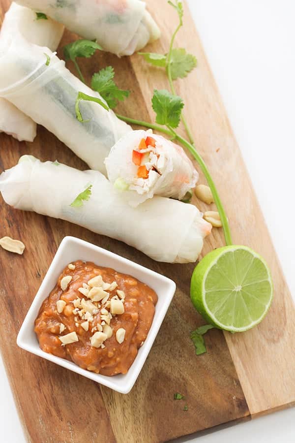 chicken rice paper rolls on a wooden serving board.
