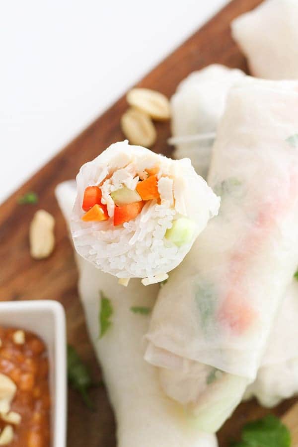 chicken rice paper rolls on a wooden serving board.