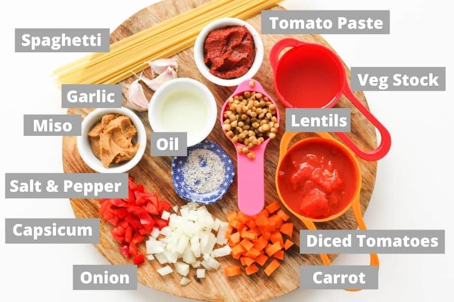 ingredients for lentil bolognese on a wooden board.