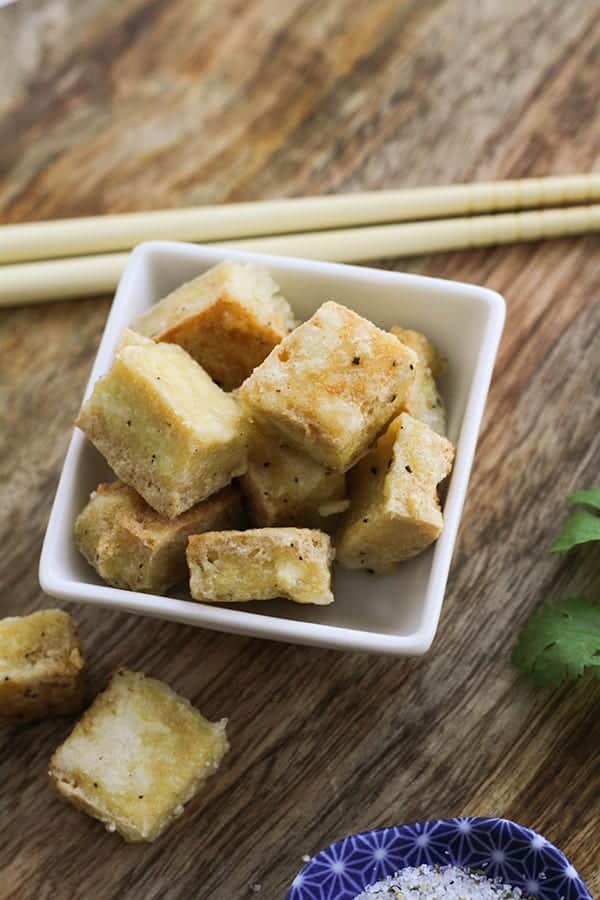salt and pepper tofu bites in a square bowl. 