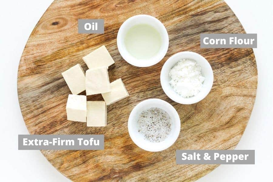 ingredients for salt and pepper tofu on a wooden board.
