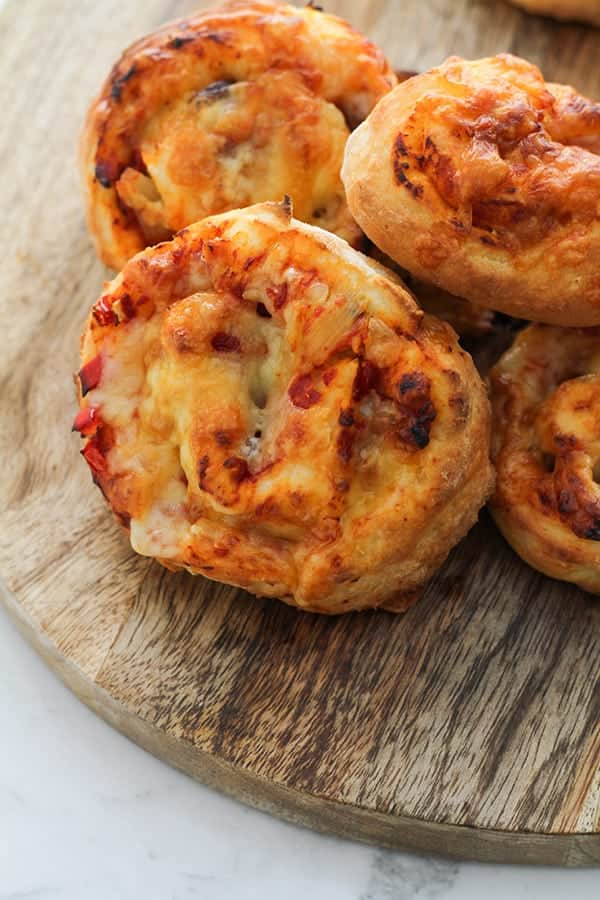 vegetarian pizza scrolls on a wooden cutting board.