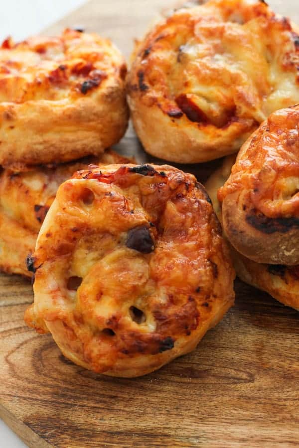 vegetarian pizza scrolls on a wooden cutting board.