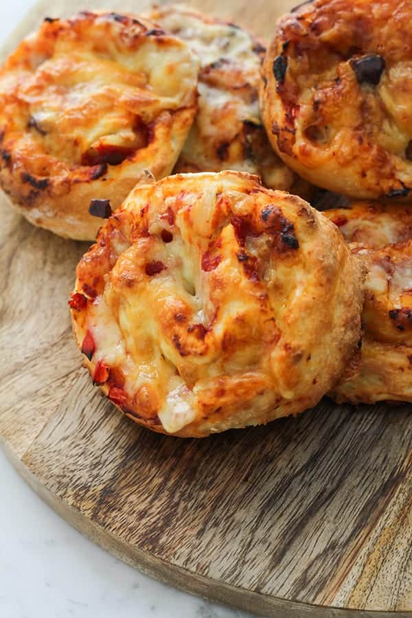 vegetarian pizza scrolls on a wooden cutting board.