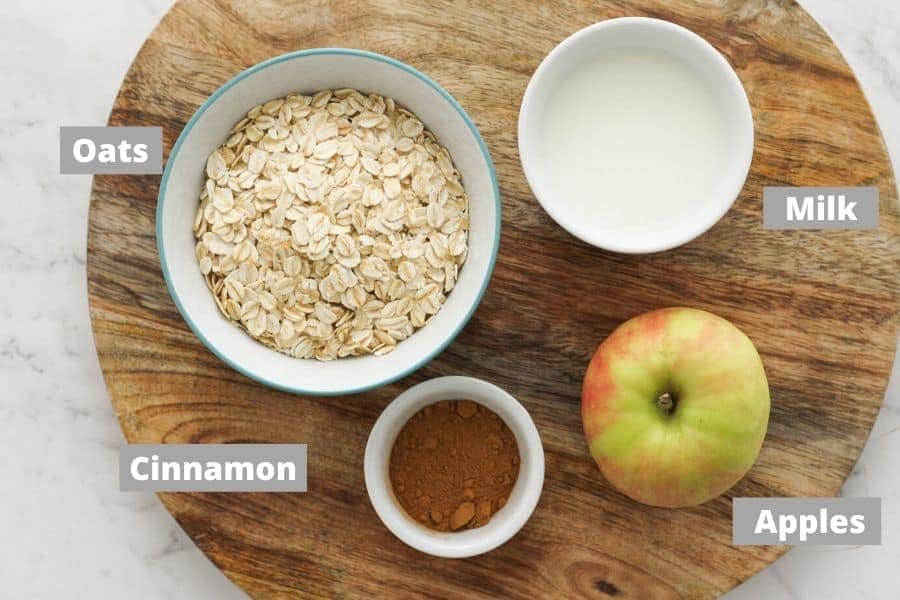 ingredients for apple cinnamon oatmeal on a wooden board. 