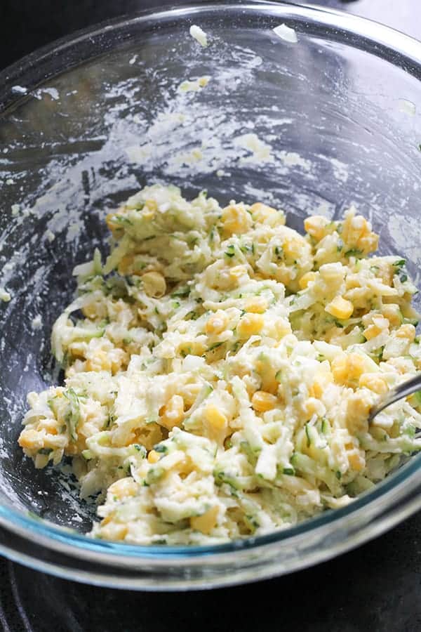 fritter ingredients mixed together in a glass mixing bowl.