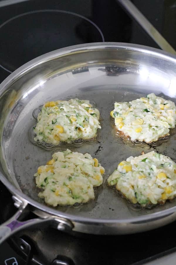 fritters cooking in a frying pan.