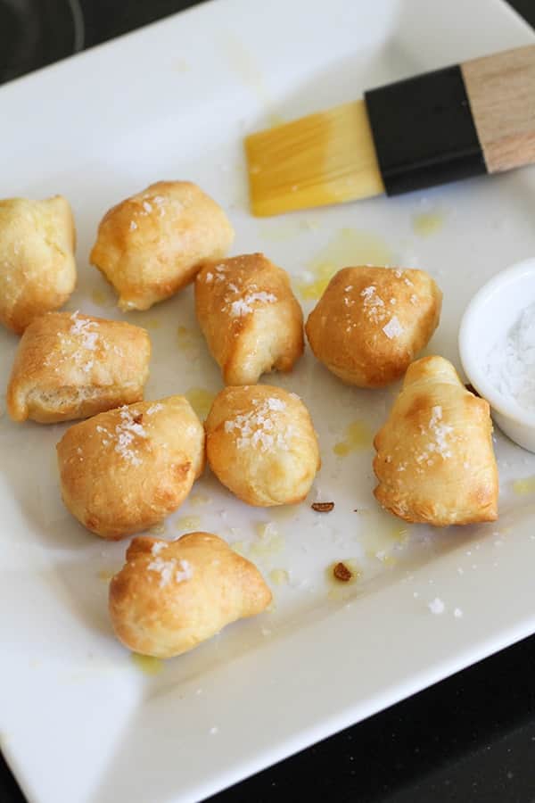 pretzel bites on a plate brushed with butter and sprinkled with salt.