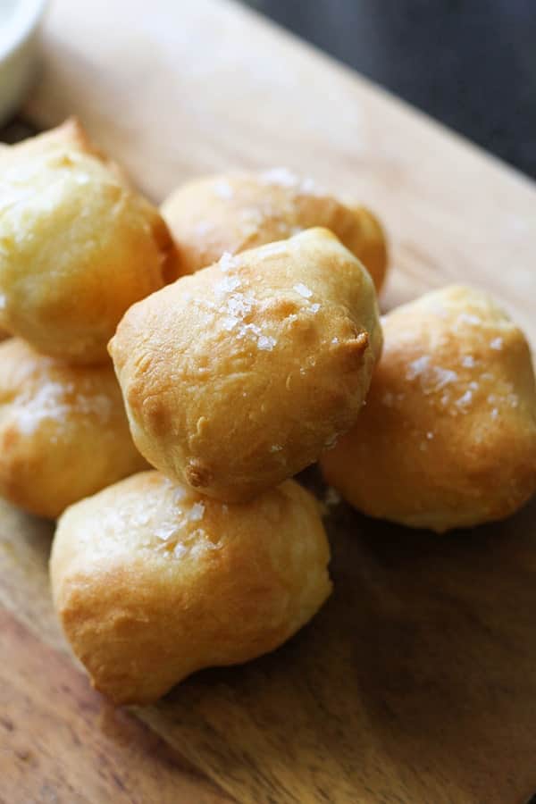 pretzel bites stacked on a wooden serving board.