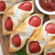 pigs in a blanket on a wooden serving board with text overlay "air fryer pigs in a blanket".