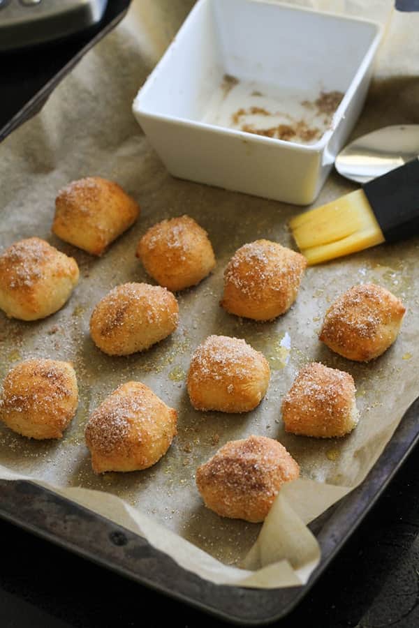 pretzel bites covered in cinnamon sugar on a baking tray.
