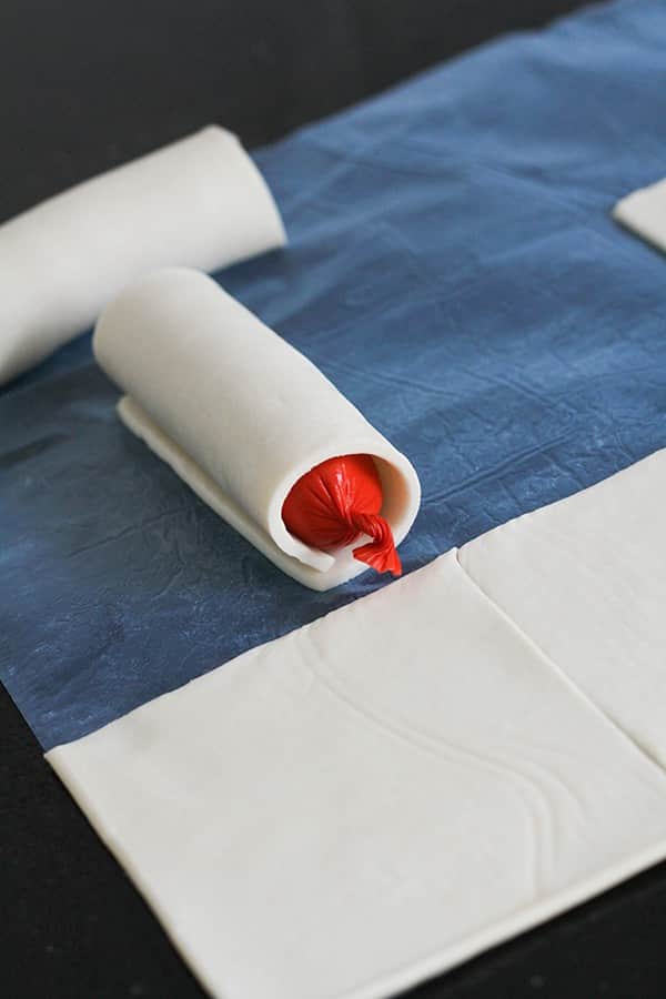 a cocktail frankfurt wrapped in a puff pastry square.