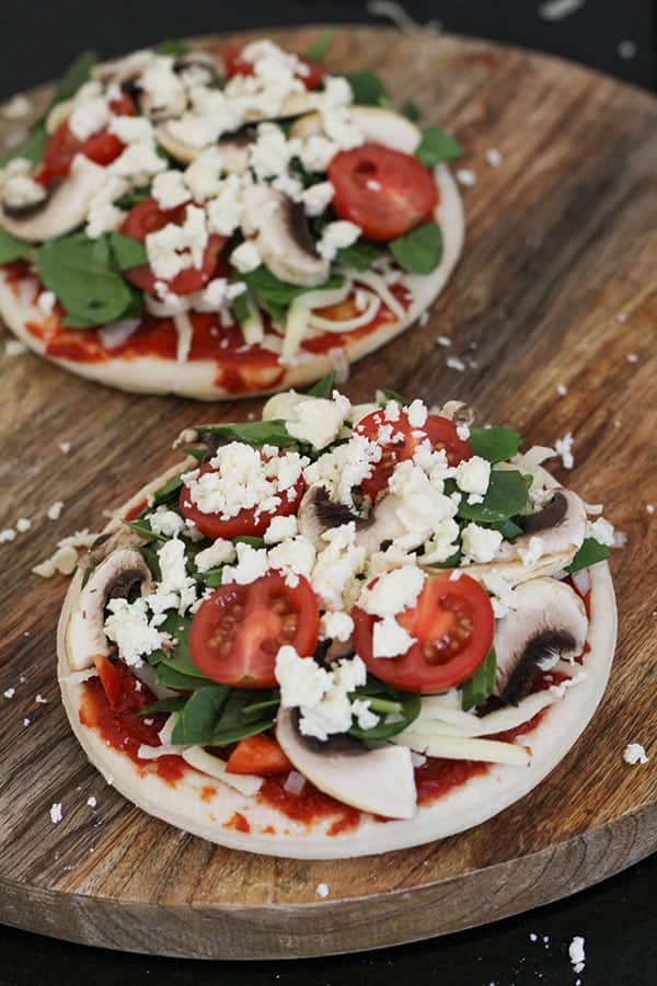 pizza bases topped with ingredients ready for the oven.