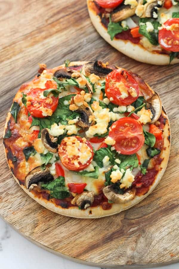 pizzas on a wooden serving board.