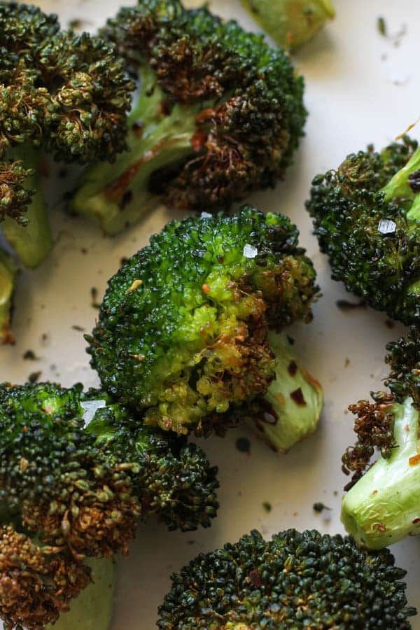 roasted broccoli on a white plate.