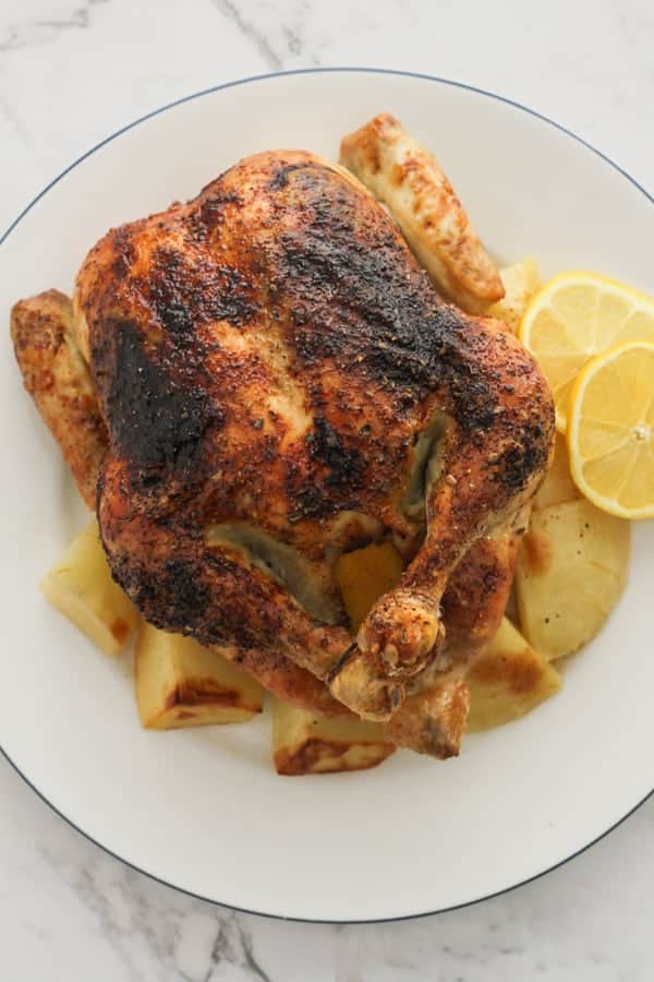 roast chicken and potatoes on a white plate.