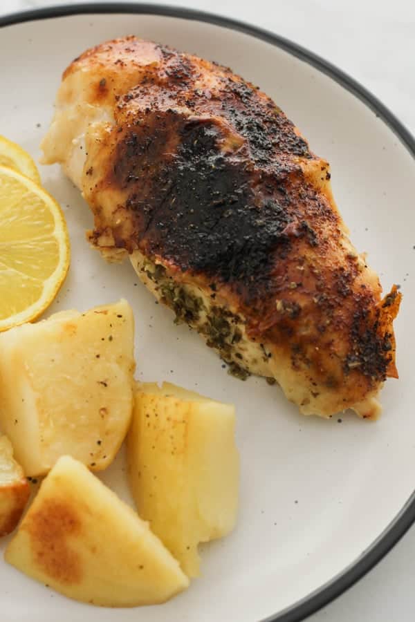 chicken and potatoes on a white plate.