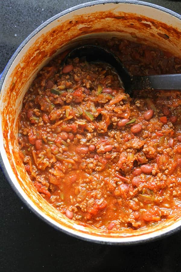 a large pot of chilli con carne with a ladle submerged into the chilli.