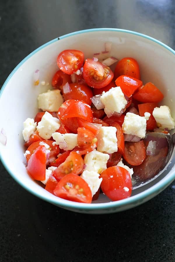 diced tomatoes, onion and feta in a bowl.