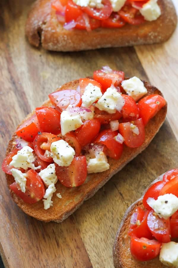 bruschetta on a wooden serving board.