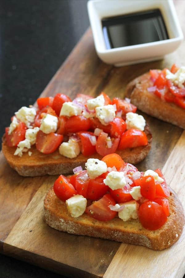 bruschetta on a wooden serving board.