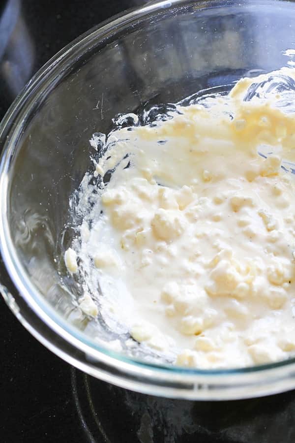 feta, egg and onion mixed together in a glass bowl.