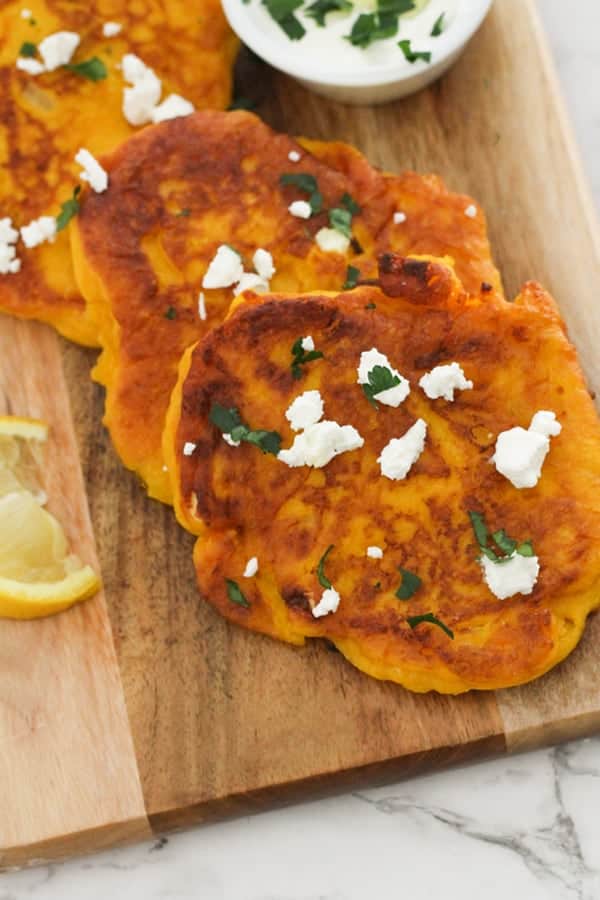 pumpkin fritters laid on top of a wooden board.