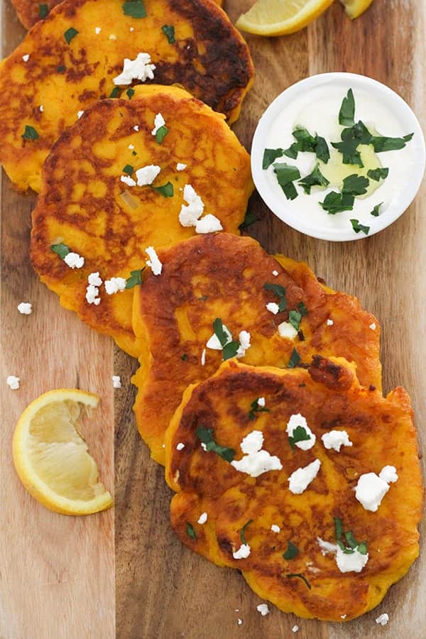 pumpkin fritters laid on top of a wooden board.